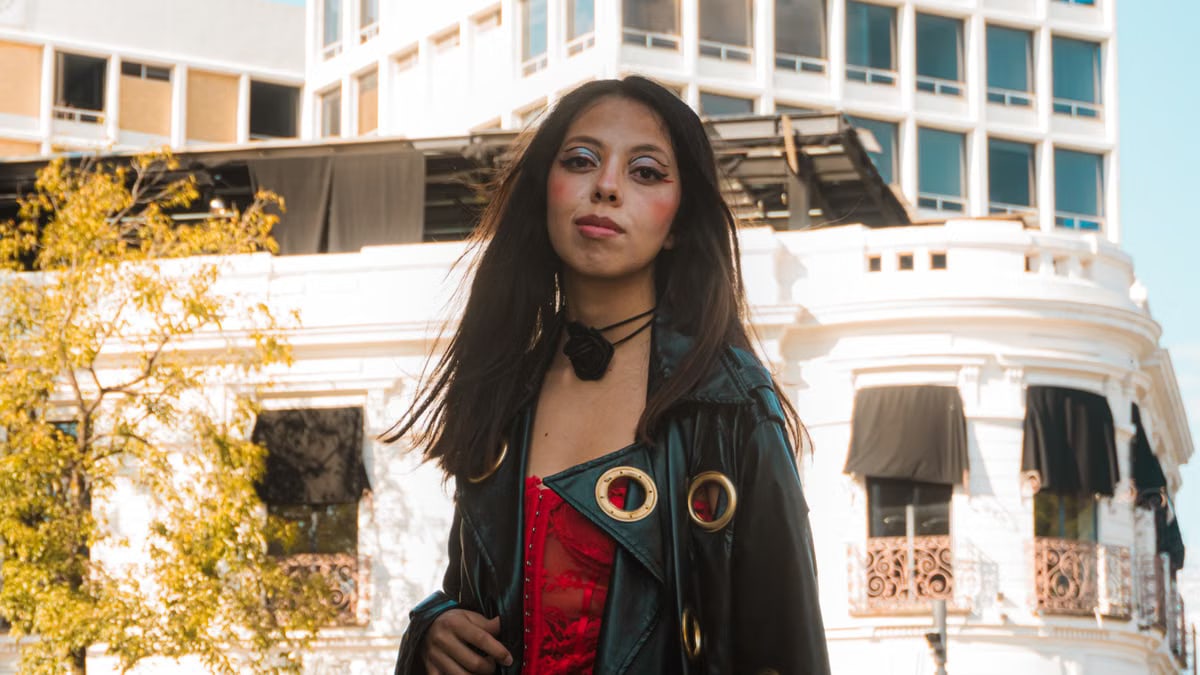 Stylish woman in vibrant attire against historic Puebla, Mexico cityscape.